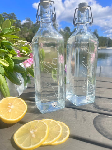 Vattenflaskor (2) från Orrefors - handgraverade med ”Stilla” och ”Bubbel”