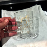 Hand som håller i kaffemugg av glas med guldgraverad text You're too sweet och ett hjärta. 