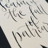 Närbild av text skriven med svart bläck och en kalligrafipenna