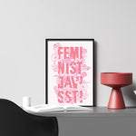 Inramad bild med grafisk illustration och text Feminist Javisst! med rosa blommor och rosa text. 