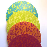 glasunderlägg med orden skål, i olika färger 