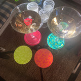 Glasunderlägg i glada färger som det står Skål på 