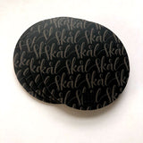 ett set med fyra svarta underlägg som det står skål på i grå handskriven skript. 